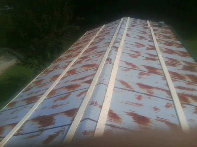 Rusted metal roof panels with new wood purlins before replacement — Storm Damage Roof Repair in Junction by Roofing Brothers